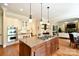 An open kitchen has a gas cooktop and island seating with access to living room at 5827 Rileys Ridge Rd, Charlotte, NC 28226