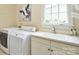 A practical laundry room includes a sink and modern washer and dryer at 5827 Rileys Ridge Rd, Charlotte, NC 28226