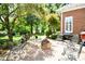 Charming brick patio with outdoor seating, fire pit, grill, and lush landscaping offering a perfect space for entertaining at 5827 Rileys Ridge Rd, Charlotte, NC 28226