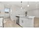 Bright kitchen with white cabinets, a stainless steel dishwasher, and an island with a sleek black faucet at 622 Old Salisbury Rd, Statesville, NC 28677