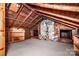 Rustic attic featuring wooden beams, stone chimney, and ample storage space at 6510 Sharon Hills Rd, Charlotte, NC 28210
