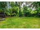 Backyard featuring a lush lawn surrounded by mature trees and shrubbery at 6510 Sharon Hills Rd, Charlotte, NC 28210