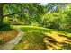 Large backyard featuring mature trees, a well-manicured lawn, and a stone pathway creating a peaceful retreat at 6510 Sharon Hills Rd, Charlotte, NC 28210