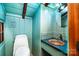Small bathroom with light blue walls, a round mirror, custom sink, and white toilet at 6510 Sharon Hills Rd, Charlotte, NC 28210