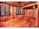 Cozy bedroom with hardwood floors, wood-paneled walls and ceiling, windows with wooden blinds, and built-in closet at 6510 Sharon Hills Rd, Charlotte, NC 28210