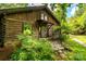 Exterior log cabin with stone path in a lush, green setting at 6510 Sharon Hills Rd, Charlotte, NC 28210