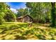 Charming log cabin with a well-maintained lawn, surrounded by lush trees for privacy at 6510 Sharon Hills Rd, Charlotte, NC 28210