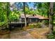 Log cabin with deck and parking featuring a natural landscape with mature trees and foliage at 6510 Sharon Hills Rd, Charlotte, NC 28210