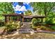 Charming log cabin home featuring stone steps, lush landscaping, and a serene, wooded setting at 6510 Sharon Hills Rd, Charlotte, NC 28210