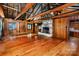 Open living room with hardwood floors, exposed beams, fireplace, and rustic wood paneling at 6510 Sharon Hills Rd, Charlotte, NC 28210