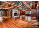 Large living room with hardwood flooring, exposed beams, stone fireplace, and built-in shelving at 6510 Sharon Hills Rd, Charlotte, NC 28210