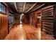 Spacious living room with wood-paneled walls, hardwood flooring, and multiple doorways for easy access at 6510 Sharon Hills Rd, Charlotte, NC 28210