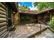 Outdoor patio with stone flooring, log cabin walls, and entry to the screened in porch at 6510 Sharon Hills Rd, Charlotte, NC 28210
