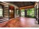Screened porch with wood flooring, log cabin walls, rustic door, and view to landscape at 6510 Sharon Hills Rd, Charlotte, NC 28210