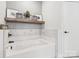 Spa-like bathroom featuring a soaking tub, marble-look tiling, and decorative shelf at 754 Culp Ferguson Rd, Lancaster, SC 29720
