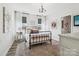 Charming bedroom boasts a wrought iron bed frame, stylish chandelier, and large windows with sheer curtains at 754 Culp Ferguson Rd, Lancaster, SC 29720