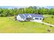 Exterior elevation of white home with 3-car garage, front porch, and meticulously landscaped front yard at 754 Culp Ferguson Rd, Lancaster, SC 29720