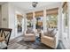 Bright sunroom featuring a pair of chairs with decorative pillows, natural shades, and durable wood-look flooring at 754 Culp Ferguson Rd, Lancaster, SC 29720