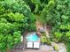 Aerial view showcasing a backyard pool, deck, landscaped yard, and the surrounding lush greenery at 8524 Quarters Ln, Mint Hill, NC 28227