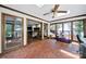Bright sunroom featuring mosaic tile floors, skylights, ceiling fan, and views to the living room and wooded yard at 8524 Quarters Ln, Mint Hill, NC 28227