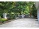 Outdoor entertaining area with a built-in grill, stone patio, and lush landscaping at 9814 Fernspray Rd, Charlotte, NC 28215