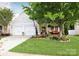Charming home with a lush green lawn and inviting front porch with vibrant red seating at 9814 Fernspray Rd, Charlotte, NC 28215