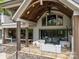 Back porch features wood ceiling, dining and living areas with comfortable white furniture at 10170 Enclave Cir, Concord, NC 28027