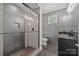 Modern bathroom with glass shower, dark vanity, and gray tile at 10170 Enclave Cir, Concord, NC 28027