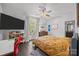Comfortable bedroom with dark hardwood floors, large TV, and private access to outdoor balcony at 10170 Enclave Cir, Concord, NC 28027
