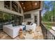 Inviting covered patio featuring a stone floor, stylish white seating, and a built-in television for outdoor enjoyment at 10170 Enclave Cir, Concord, NC 28027