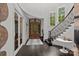 Bright foyer featuring curved staircase, wood floors, and charming architectural details at 10170 Enclave Cir, Concord, NC 28027