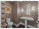 Unique powder room featuring patterned wallpaper, pedestal sink, and modern lighting at 10170 Enclave Cir, Concord, NC 28027