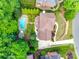Overhead view of property showing the in-ground pool, lush landscaping, patio and a full view of the roof at 10327 Oak Pond Cir, Charlotte, NC 28277