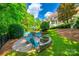 Lush backyard featuring a stone patio with firepit, swimming pool, and manicured landscaping, perfect for outdoor enjoyment at 10327 Oak Pond Cir, Charlotte, NC 28277