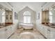 Bright bathroom with a clawfoot tub, decorative tile flooring, and -and- sink vanities at 10327 Oak Pond Cir, Charlotte, NC 28277