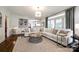 Bright living room boasts large windows, hardwood floors, and a neutral palette, creating an inviting and elegant space at 10327 Oak Pond Cir, Charlotte, NC 28277