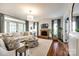 Cozy living room featuring a brick fireplace, comfortable seating, and hardwood floors at 10327 Oak Pond Cir, Charlotte, NC 28277