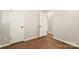 A bedroom with two white doors, laminate flooring, and freshly painted neutral walls at 104 Berry St, Fort Mill, SC 29715