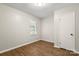 Bedroom featuring neutral walls, wood-look flooring, one window with white blinds, and interior door at 104 Berry St, Fort Mill, SC 29715