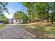 Charming single-story home with a gravel driveway and a spacious, wooded lot, perfect for outdoor activities at 104 Berry St, Fort Mill, SC 29715