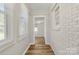 Hallway featuring brick wall, white trim, grey walls, and view into a bedroom at 104 Berry St, Fort Mill, SC 29715
