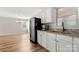 Bright kitchen area showcasing updated stainless steel refrigerator, granite countertops, and wood look flooring at 104 Berry St, Fort Mill, SC 29715
