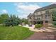 Expansive backyard featuring a stone patio, fire pit, lush landscaping, and stately home at 11000 Strike The Gold Ln, Waxhaw, NC 28173