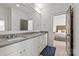 Well-lit bathroom featuring a large vanity with double sinks and a view into an adjacent bedroom at 11000 Strike The Gold Ln, Waxhaw, NC 28173