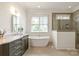 Luxurious bathroom with a soaking tub, marble vanity, and a separate glass-enclosed shower at 11000 Strike The Gold Ln, Waxhaw, NC 28173