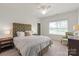 Cozy bedroom with a tufted headboard, white bedding, side tables, and a sitting chair at 11000 Strike The Gold Ln, Waxhaw, NC 28173