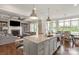 Open-concept kitchen with island, stainless steel appliances, and seamless flow to the living and dining areas at 11000 Strike The Gold Ln, Waxhaw, NC 28173