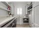 Well-organized laundry room with built-in cabinets, open shelving, and a countertop for folding at 11000 Strike The Gold Ln, Waxhaw, NC 28173