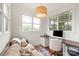 Cozy home office with a comfortable couch, a practical desk setup, and natural light from two windows at 11000 Strike The Gold Ln, Waxhaw, NC 28173