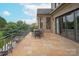 Large stone patio with dining furniture, and home's elegant brick exterior at 11000 Strike The Gold Ln, Waxhaw, NC 28173